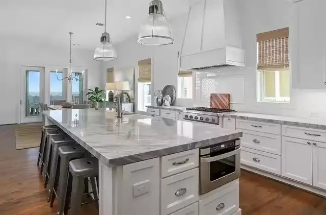 Kitchen island with marble top and bar seating in a Galveston home remodel