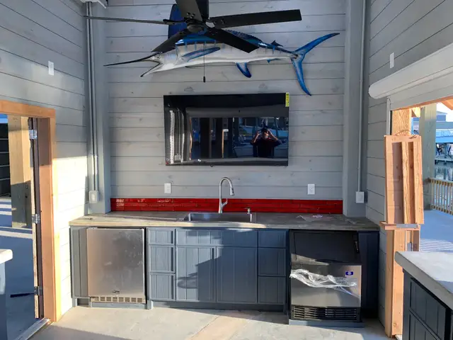 Outdoor bar with sink, cabinets and shiplap wall built on a Galveston waterfront property